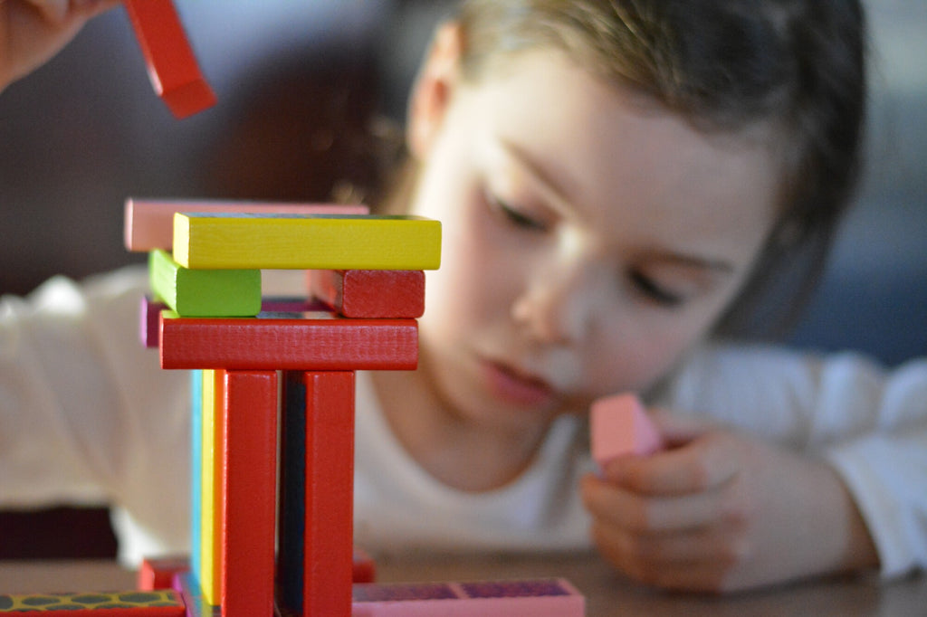 Young girl stacking educational toy blocks