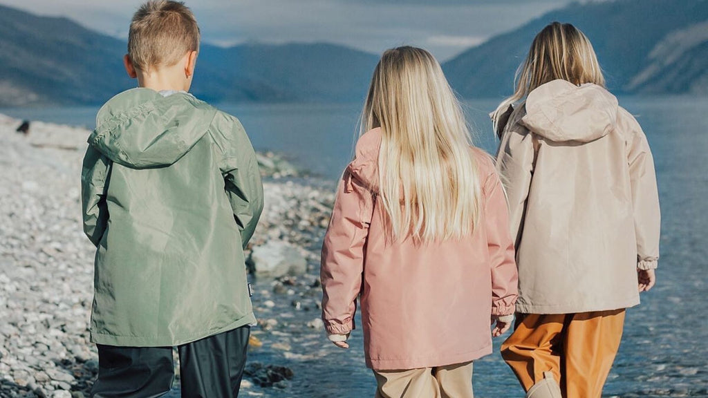 The back of three kids wearing waterproof clothing